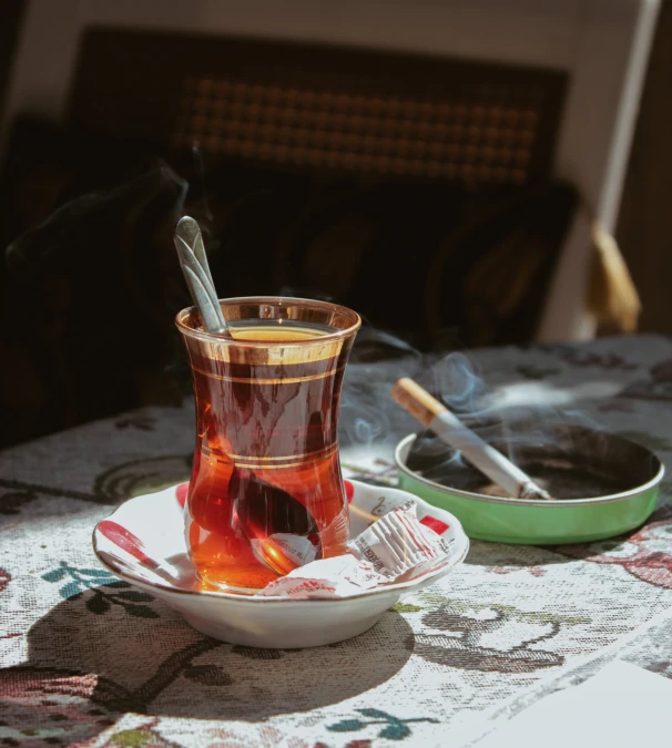 a cup of tea sitting on top of a table, by irakli nadar, hurufiyya, taking tobacco snuff, brown, afternoon, high quality product image”