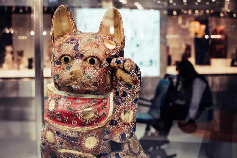 a statue of a cat on display in a glass case, a photo, by Julia Pishtar, unsplash, cloisonnism, over-shoulder shot, an intricate, demur, eastern art style