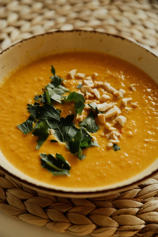 a bowl of soup sitting on top of a table, vibrant orange, nuttavut baiphowongse, square, premium