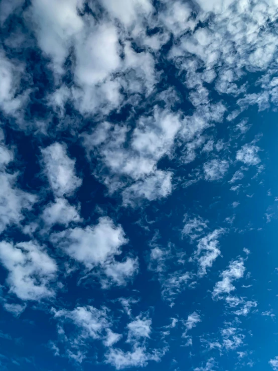 a person is flying a kite high in the sky, layered stratocumulus clouds, today\'s featured photograph 4k, blue, taken with sony alpha 9