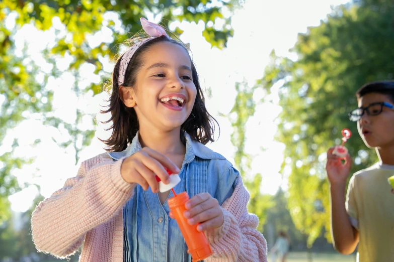 a couple of kids standing next to each other, pexels contest winner, holding a bottle, having fun in the sun, candy treatments, profile image