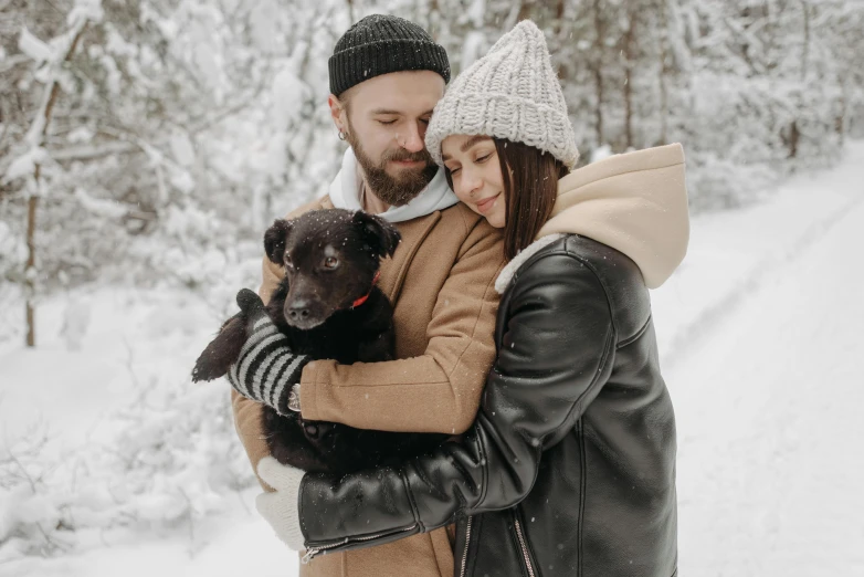 a man and woman holding a dog in the snow, pexels contest winner, leather clothing, avatar image, brunette, australian