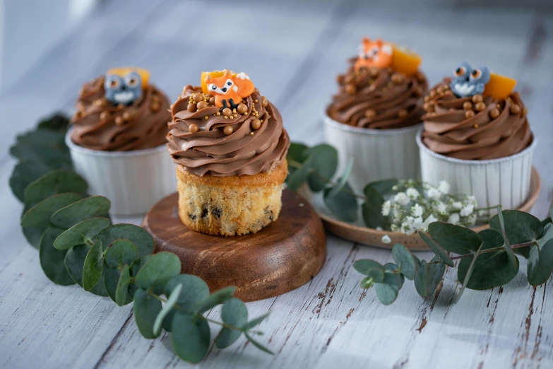 a table topped with cupcakes covered in frosting, a portrait, by Bernardino Mei, pexels, 3 woodland critters, grey orange, square, high resolution product photo