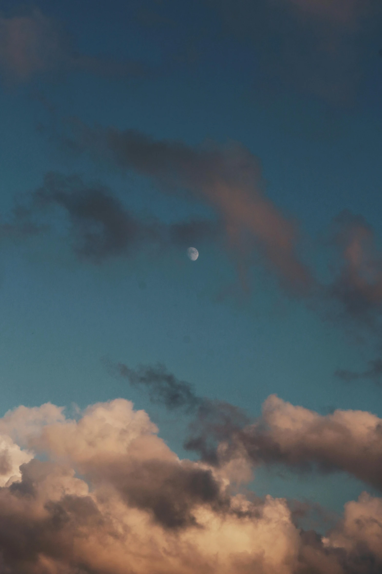 a plane flying through a cloudy blue sky, a picture, unsplash, moon rising, paul barson, soft light.4k, distant - mid - shot