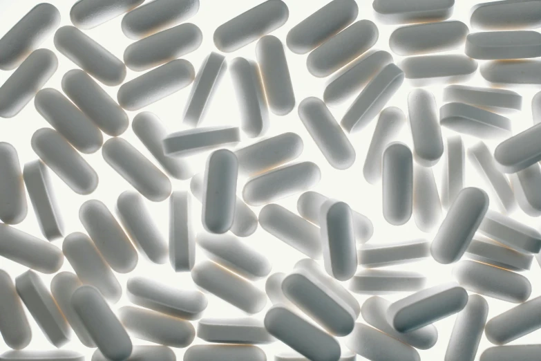 a bunch of pills sitting on top of a table, white fractals, subtle detailing, grey, rows of razor sharp teeth