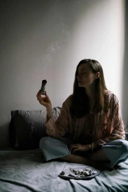 a woman sitting on a bed smoking a cigarette, inspired by Elsa Bleda, pexels contest winner, renaissance, holding a small vape, emily rajtkowski, 4 2 0, portrait of tall