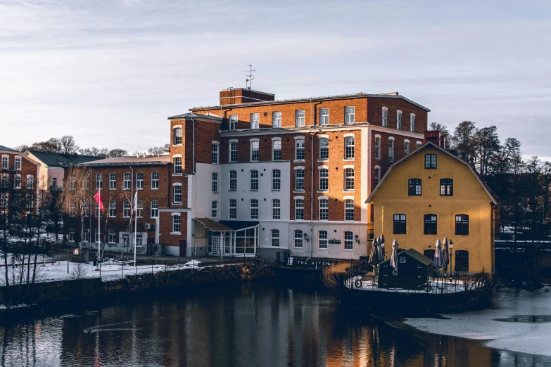 a large building sitting next to a body of water, inspired by Wilhelm Marstrand, pexels contest winner, mill, riverside, thumbnail, exterior photo