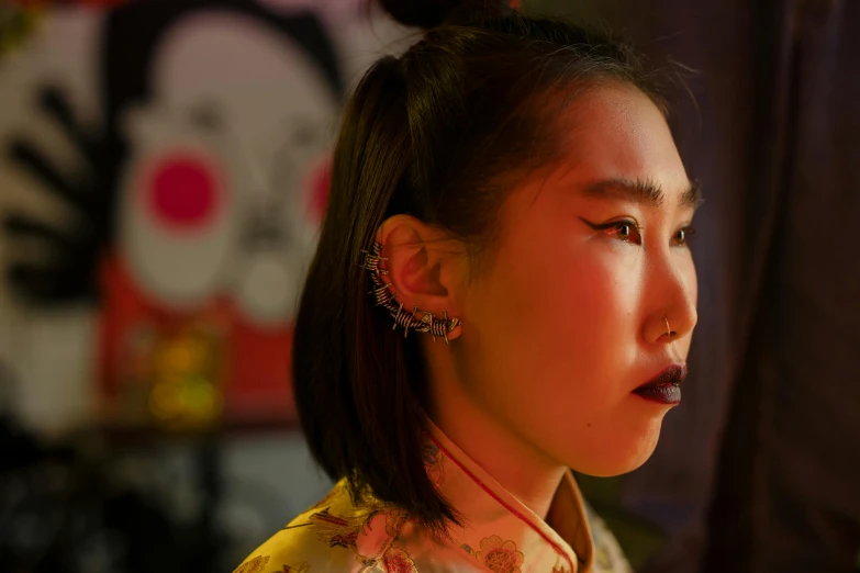 a close up of a person with a cell phone, an album cover, inspired by Xie Huan, trending on pexels, ukiyo-e, huge earrings and queer make up, evening lighting, gauged ears, chinese heritage