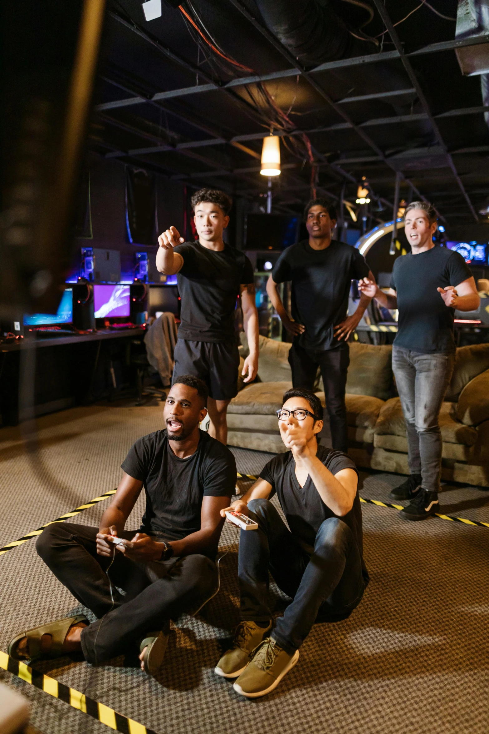 a group of people sitting on the ground playing video games, a portrait, by Everett Warner, interactive art, standing in a starbase bar, production ig studios, lgbtq, nvidia promotional image