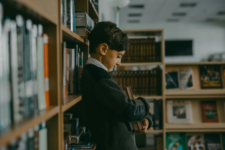 a young boy reading a book in a library, pexels contest winner, ashcan school, standing sideways, lachlan bailey, profile picture, thumbnail