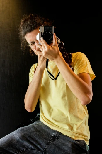 a man taking a picture with a camera, wearing a modern yellow tshirt, photography], portfolio, college