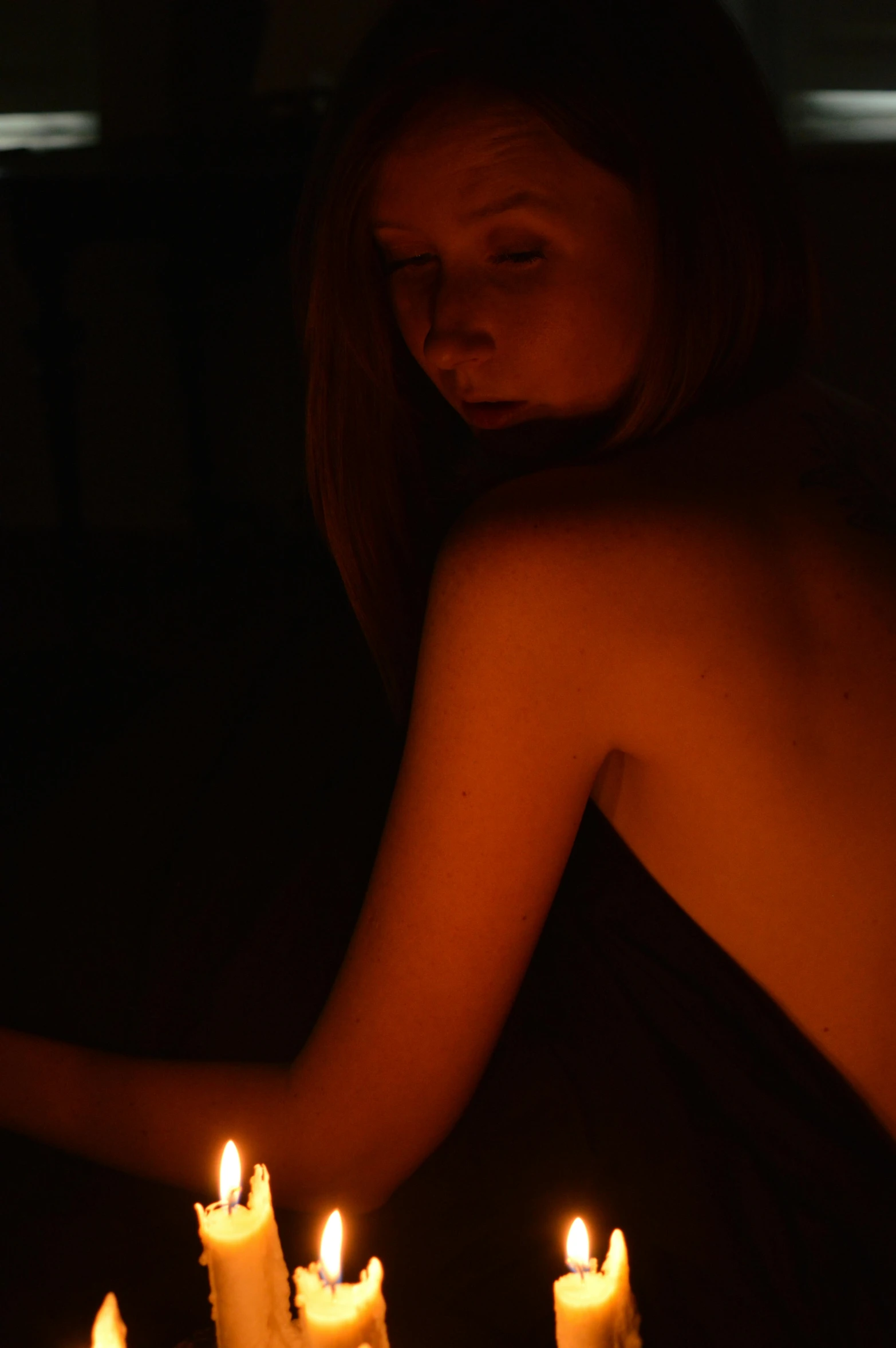 a naked woman sitting in front of a cake with lit candles, inspired by Nan Goldin, unsplash, digital art, calm night. over shoulder shot, nightlight study, sunbathed skin, black light