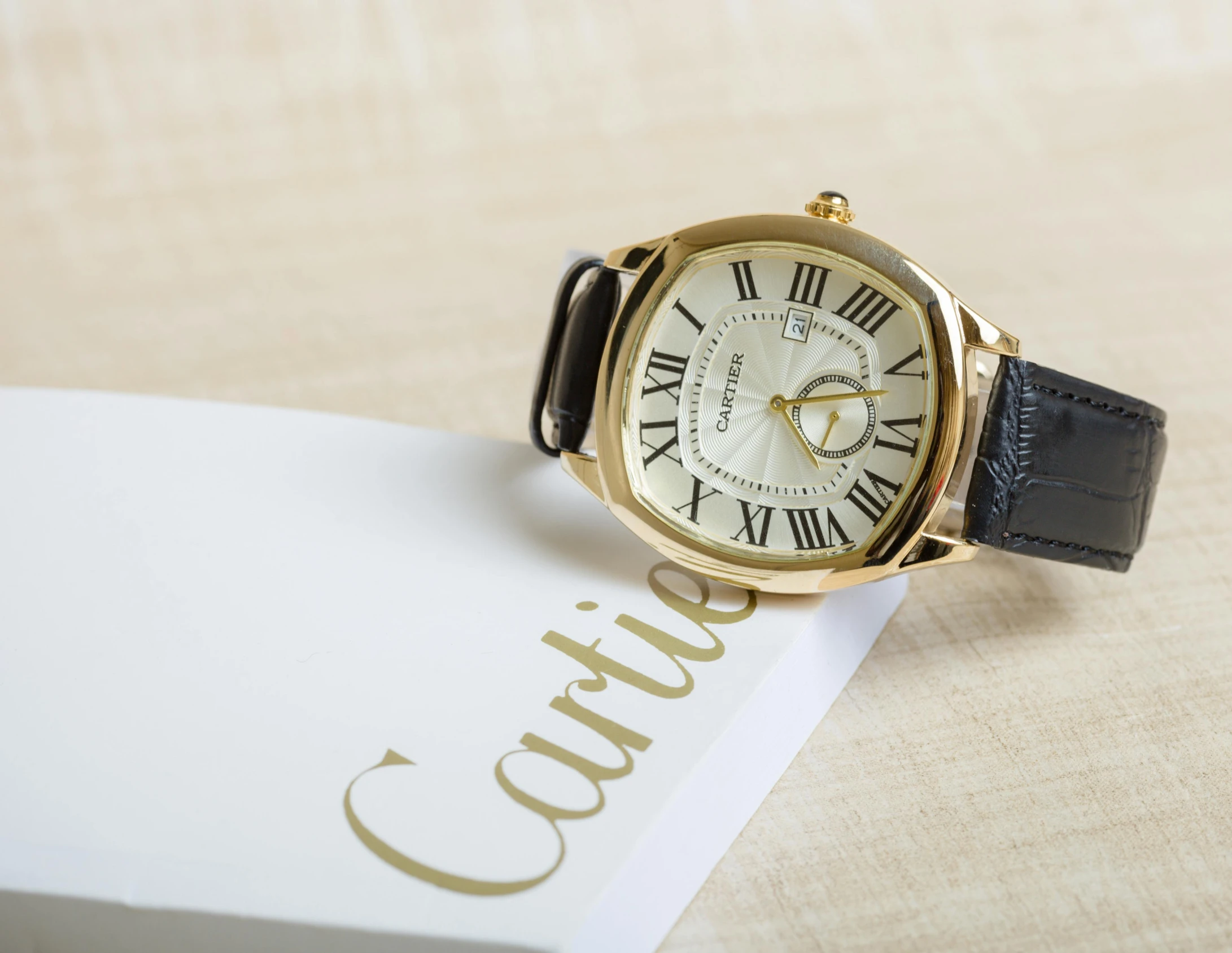 a close up of a wrist watch on a box, an album cover, inspired by Carles Delclaux Is, unsplash, baroque, cartier, on a white table, relaxed. gold background, caravagio