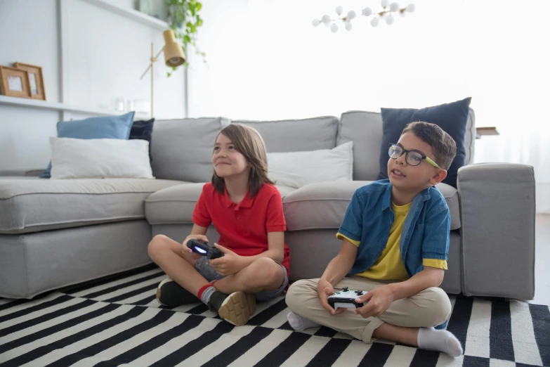 two children sitting on the floor playing video games, pexels contest winner, sitting on couch, avatar image, getty images, promotional image