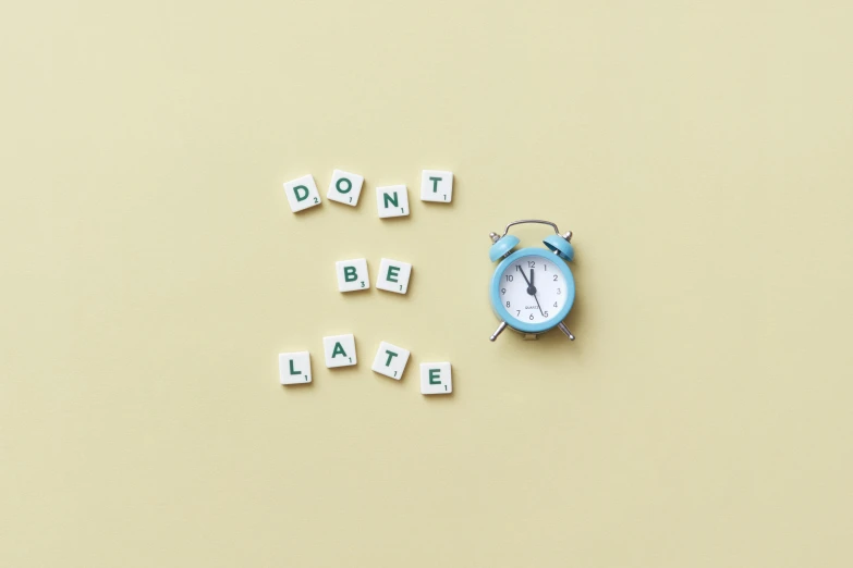 an alarm clock sitting next to the words don't be late, a picture, inspired by Chris LaBrooy, happening, on a pale background, letters, detiled, instagram post