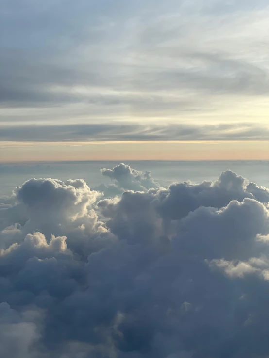 an airplane is flying high above the clouds, by Carey Morris, pexels contest winner, romanticism, panorama view of the sky, layered stratocumulus clouds, holy dice in the clouds, high angle