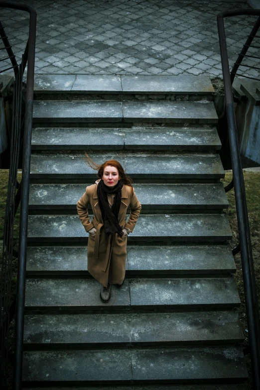 a woman standing at the top of a flight of stairs, inspired by Elsa Bleda, pexels contest winner, renaissance, redhead woman, woman is in a trenchcoat, soviet style, full frame image