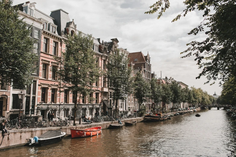 a canal filled with lots of boats next to tall buildings, a photo, by Jan Tengnagel, pexels contest winner, 🦩🪐🐞👩🏻🦳, dutch houses along a river, brown, thumbnail