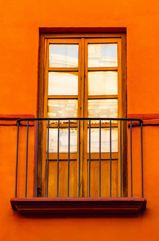 an orange building with a balcony and a window, pexels contest winner, new mexico, light reflection, french door window, ( ( railings ) )