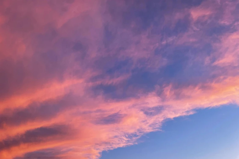 a man riding a snowboard on top of a snow covered slope, unsplash, romanticism, pink clouds in the sky, sunset panorama, cotton candy clouds, photograph of april