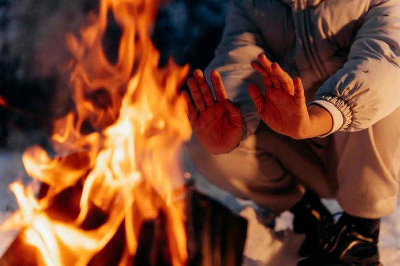 a person kneeling in front of a fire, by Julia Pishtar, pexels contest winner, his palms are sweaty, avatar image, background image, cold temperature