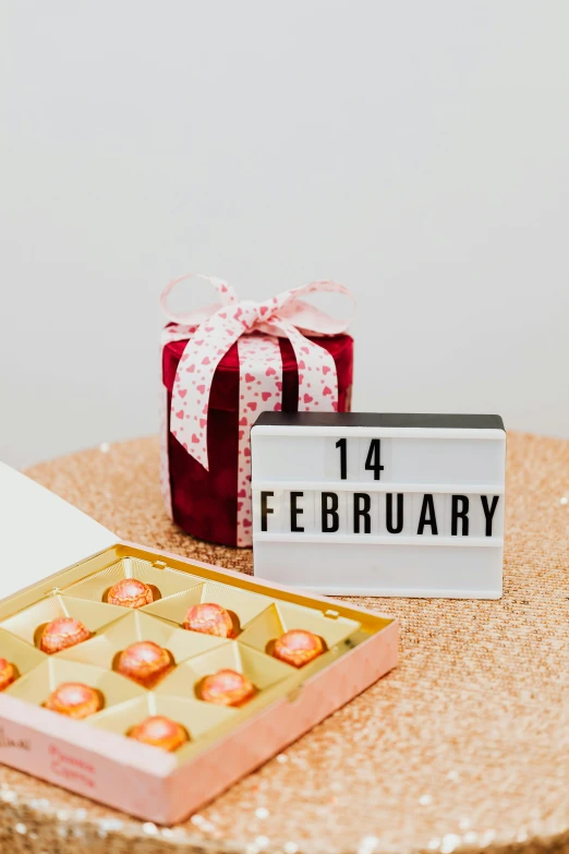 a box of chocolates sitting on top of a table, a picture, by Julia Pishtar, pexels contest winner, happening, female calendar, 1 as february), label, y