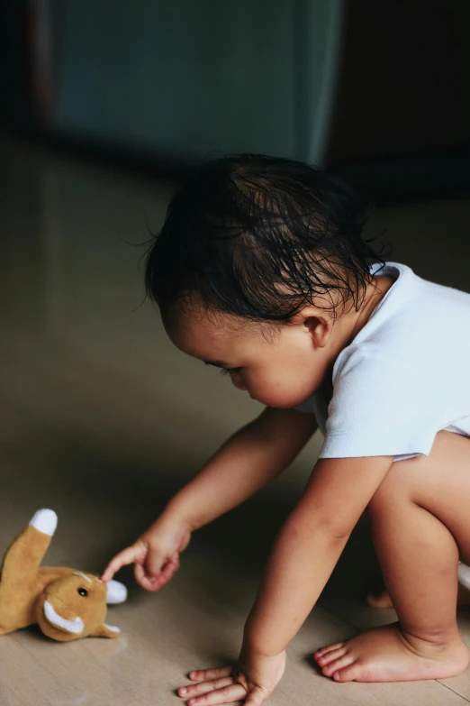 a baby in a diaper playing with a stuffed animal, by Basuki Abdullah, pexels contest winner, process art, kneeling at the shiny floor, holding a rabbit, gif, bali