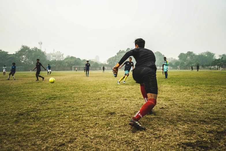 a group of young men playing a game of soccer, by Lucia Peka, pexels contest winner, panoramic shot, fan favorite, nice slight overcast weather, zezhou chen