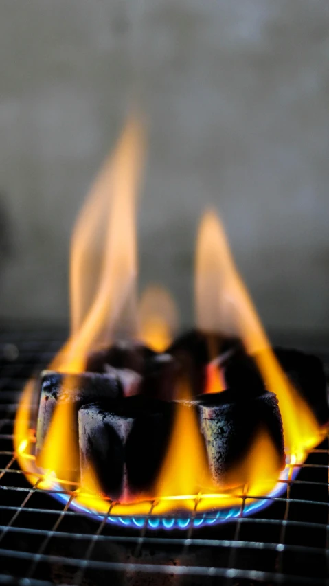 a close up of a grill with flames on it, by Paul Bird, slate, winning photograph, grey, environmental shot