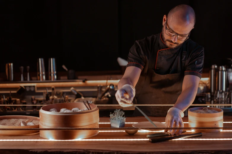 a close up of a person cutting food on a table, a portrait, inspired by Kanō Naizen, pexels contest winner, kinetic art, intricate copper details, set at night, chef table, ginko showing a new mushi