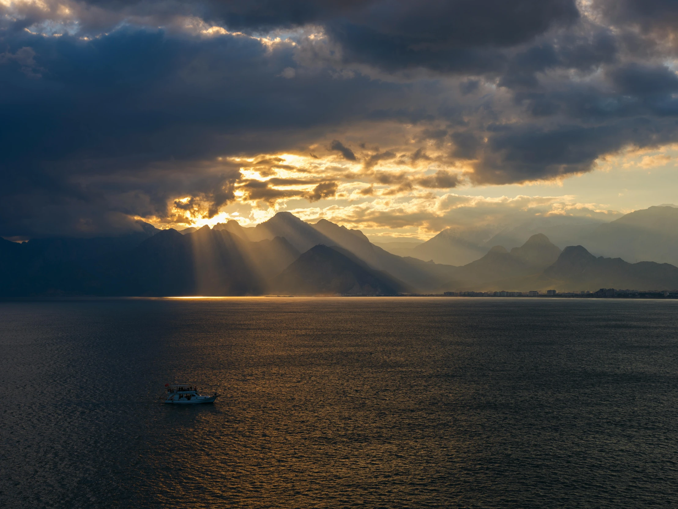 a boat floating on top of a large body of water, by Sebastian Spreng, pexels contest winner, romanticism, sunshine lighting high mountains, sun after a storm, distant mountains lights photo, a high angle shot