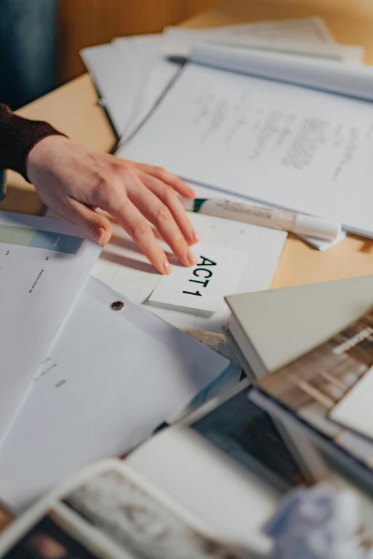 a person sitting at a table with papers and a calculator, trending on unsplash, academic art, subject action : holding sign, background image, high angle close up shot, multiple stories