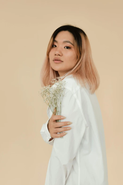 a woman in a white shirt holding a bouquet of flowers, an album cover, inspired by Ruth Jên, trending on unsplash, aestheticism, light pink hair, beautiful young asian woman, studio shoot, ombre