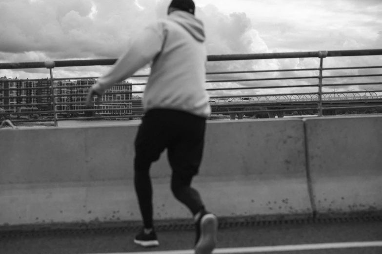 a man riding a skateboard on top of a bridge, a black and white photo, running shoes, speeding through london, profile picture, uploaded