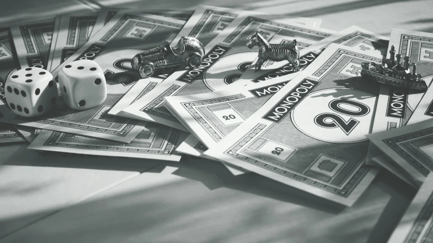 a pile of money sitting on top of a table, a black and white photo, toys, game board, monotone, thumbnail