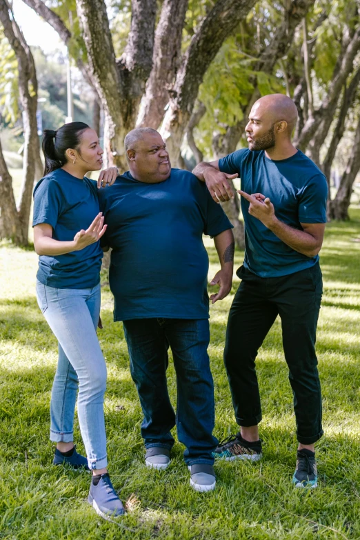 a group of people standing on top of a lush green field, wearing pants and a t-shirt, samoan features, dad bod, talking