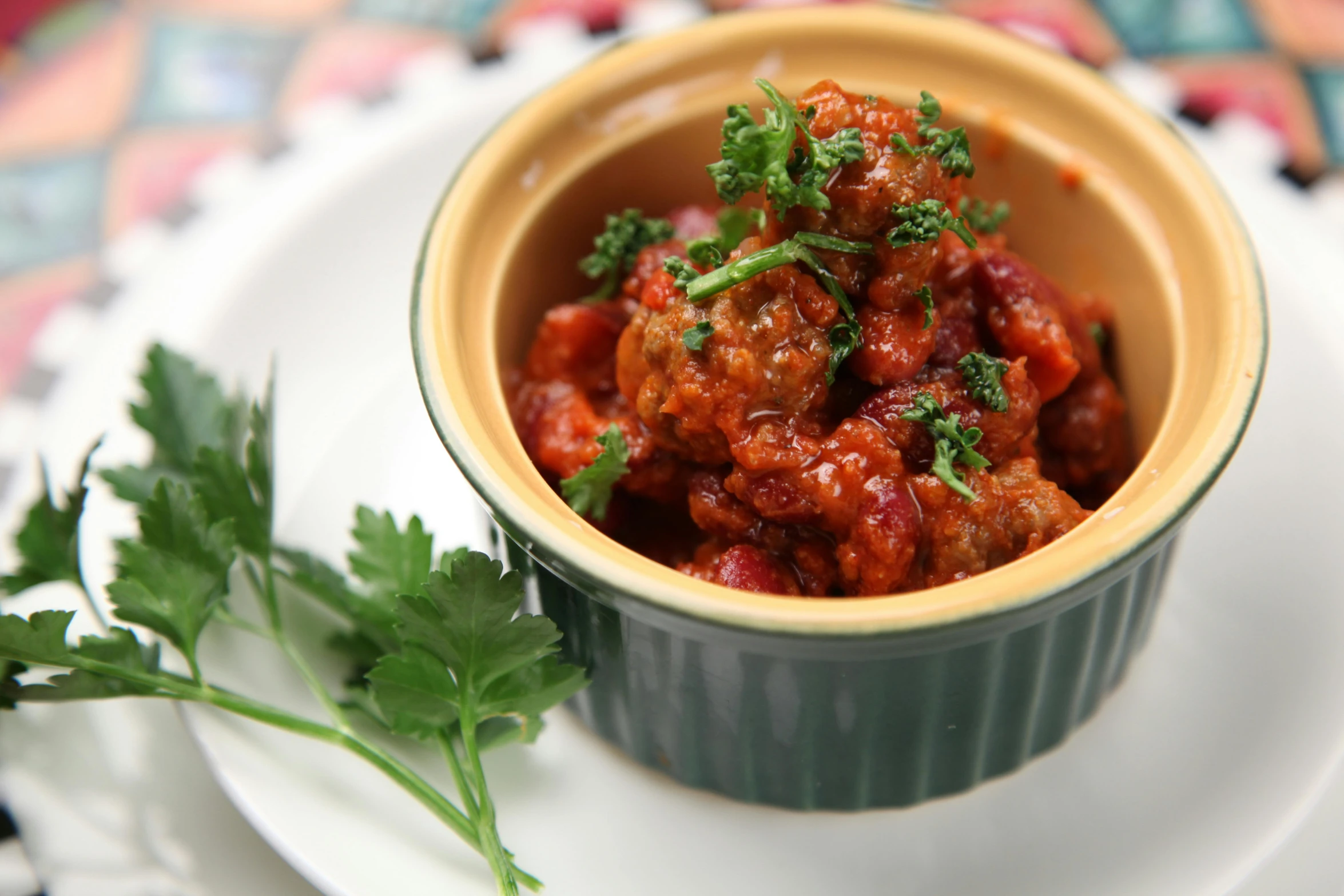 a close up of a bowl of food on a plate, tim booth, tomato sauce, stew, mint