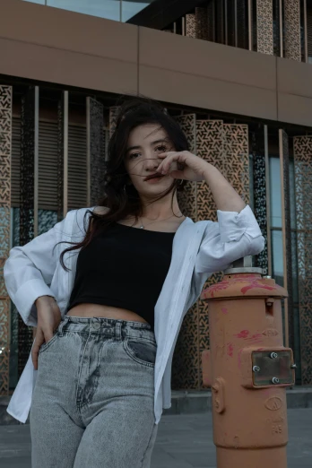 a woman standing next to a fire hydrant, an album cover, inspired by Feng Zhu, trending on pexels, realism, wearing white shirt, intimidating pose, wearing crop top, full frame image