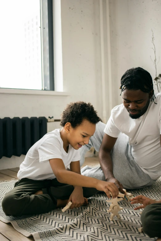 a father and son playing with blocks on the floor, a child's drawing, pexels contest winner, black man, future coder, gif, dwell