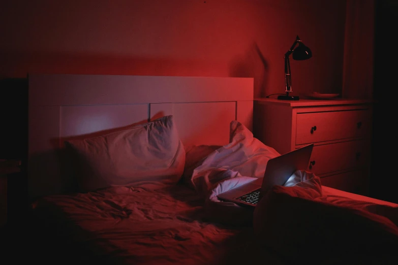 a laptop computer sitting on top of a bed, inspired by Elsa Bleda, red light, horror aesthetic, instagram picture, red