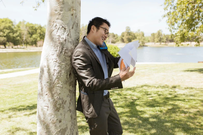 a man leaning against a tree reading a paper, wearing a suit and glasses, darren quach, surprising, avatar image