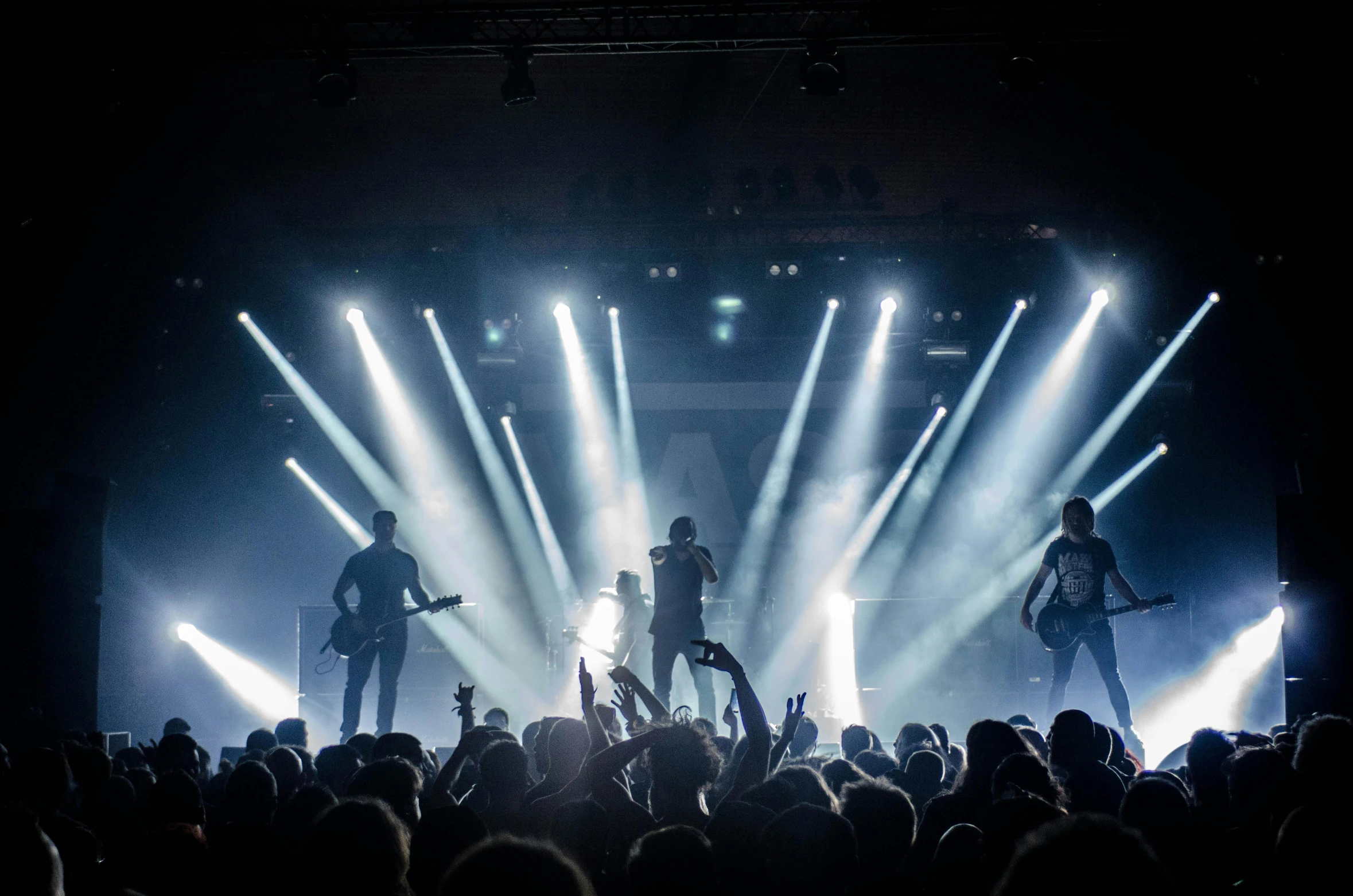 a group of people standing on top of a stage, a picture, by Adam Marczyński, pexels contest winner, live concert lighting, black lips, hammershøi, proto-metal concert