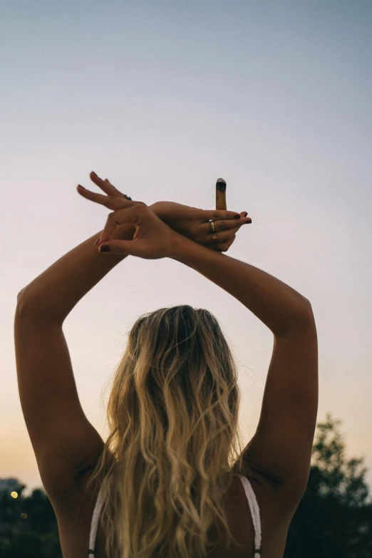 a woman standing on top of a lush green field, trending on unsplash, minimalism, hand holding cigarette, starfish pose, blonde, ((sunset))