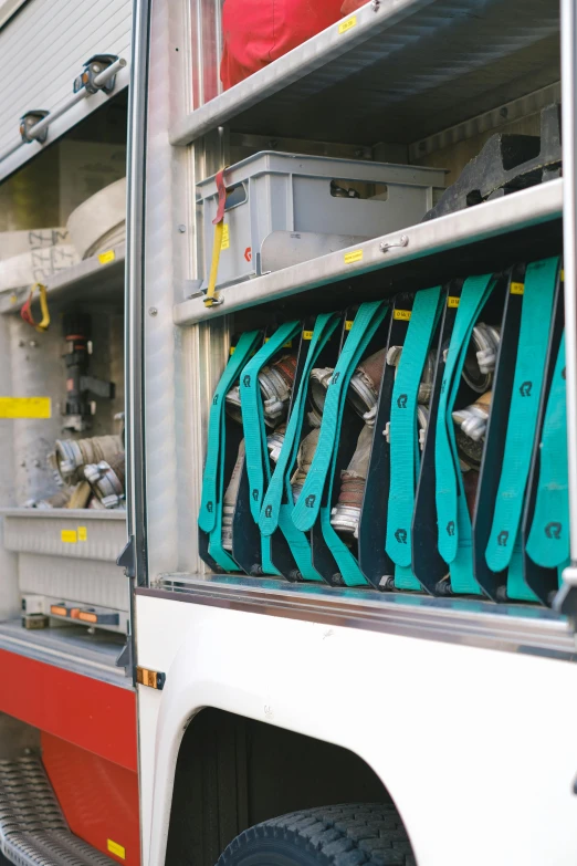 a red and white fire truck parked next to a building, small vials and pouches on belt, spanners, hdpe, grey