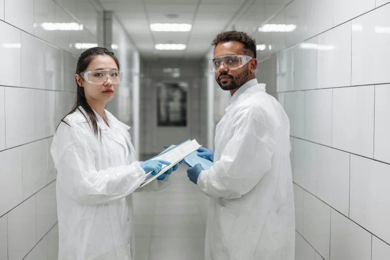 a couple of people standing next to each other in a hallway, scientific research, wearing gloves, profile image, test