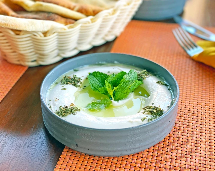 a close up of a bowl of food on a table, dau-al-set, mint higlights, yogurt, featured, humus