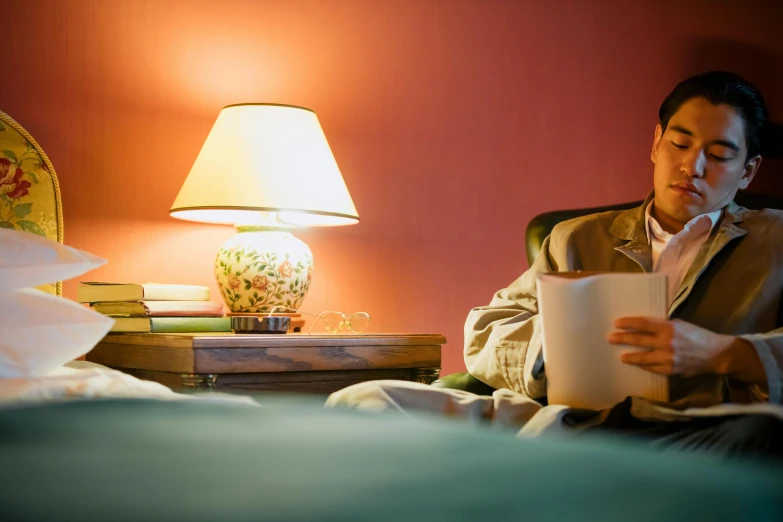 a man sitting in a chair reading a book, orange lamp, comfy lighting, cosy, room lighting