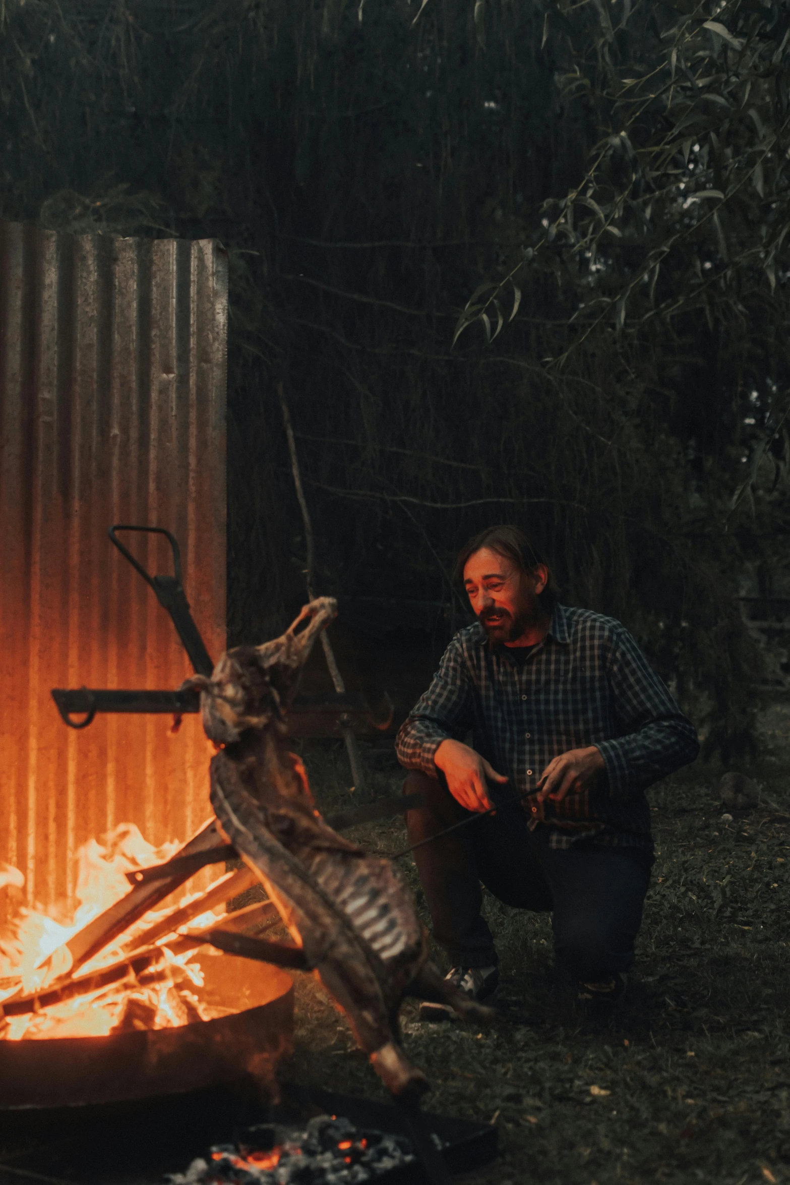 a man sitting next to a fire in a forest, australian tonalism, blacksmith product design, hillbilly, profile image, multiple stories