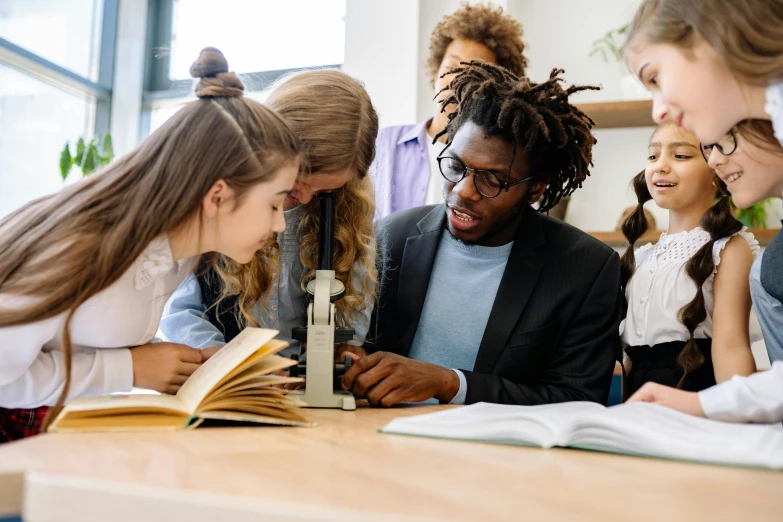 a group of young people looking at a book, trending on pexels, academic art, science lab, wooden desks with books, lachlan bailey, black
