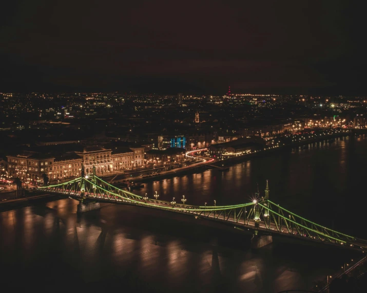 a bridge over a body of water at night, by Adam Szentpétery, pexels contest winner, bird's eye view of a city, hungarian, london at night, header text”